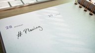 A planner page and a keyboard on a desk, ready for campaign planning